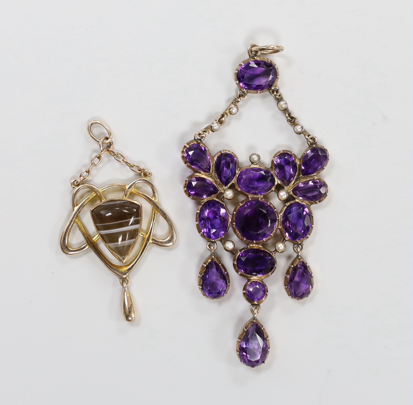 An early 20th century Art Nouveau 9ct and band agate set drop pendant, 37mm and a similar amethyst and seed pearl cluster set pendant, 62mm.